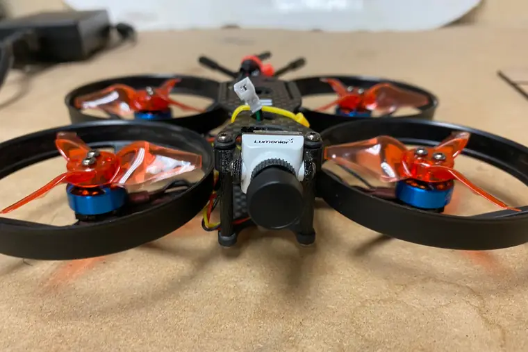 The FPV quadcopter Drew built, head-on, showing four ducted propellers and a front-mounted camera.